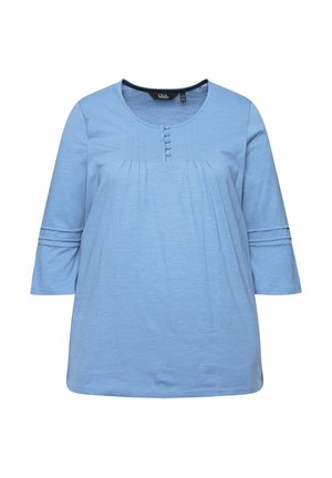 Světle modrý top s rukávy po tři čtvrtiny, kulatým výstřihem, detailem knoflíků a sklady na přední straně. Měkká tkanina s jemnou texturou.