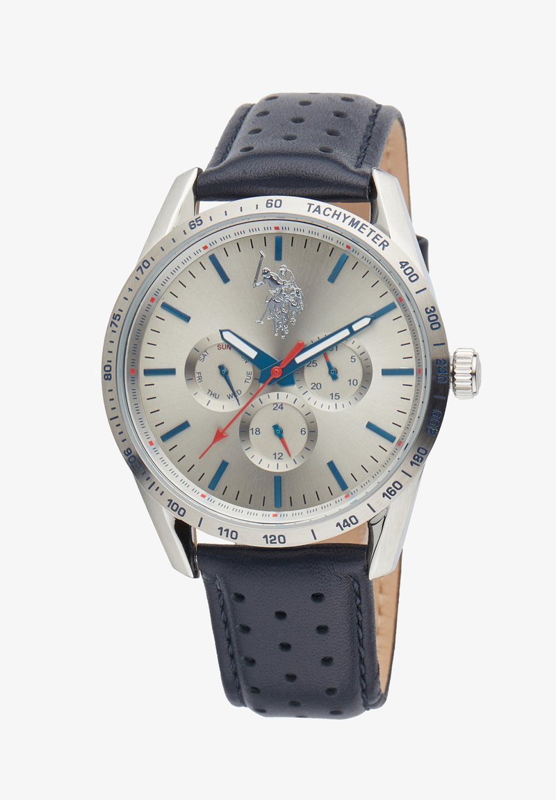 Orologio analogico da uomo con quadrante argento, indici blu, lancette rosse, cassa argentata e cinturino in pelle traforata blu scuro. Include tachimetro e sottodial.