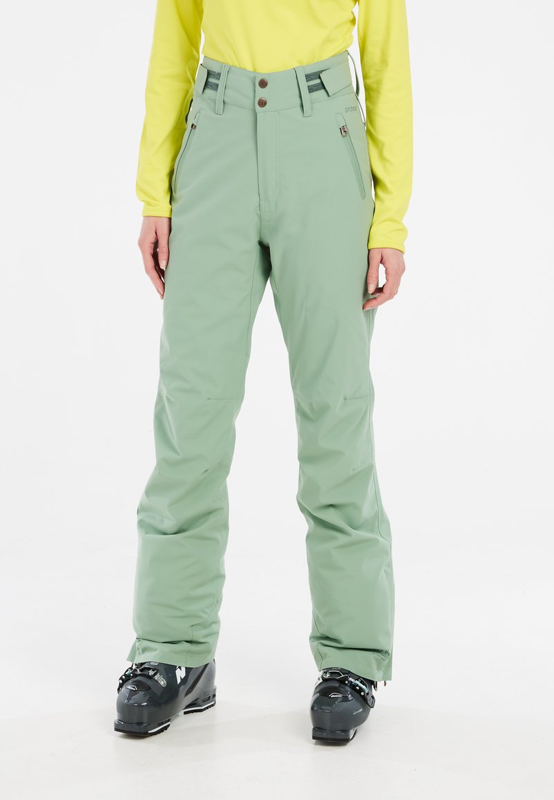 Groene skibroek van waterdicht materiaal met een relaxte pasvorm, voorzien van ritssluitingen, een knoop- en ritsluiting, en versterkte zoom.