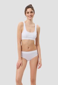 Weiße Sport-BH und passende Unterhose, gefertigt aus einem glatten, dehnbaren Stoff. Verfügt über einen quadratischen Ausschnitt und einen breiten Bund für zusätzlichen Komfort.