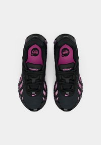 Black sports shoes with pink accents, featuring a textured upper, visible laces, and a cushioned sole with a distinct wavy design.