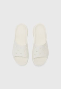 Infradito bianche realizzate in materiale morbido e flessibile, con fori di ventilazione e una suola testurizzata per una presa migliore. Design piatto, con retro aperto.