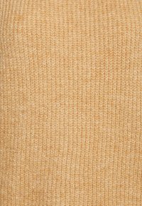 Beige knitted fabric with a soft, ribbed texture and small, evenly spaced vertical stitches.