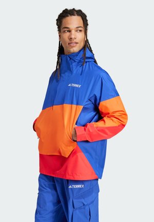 Colorful windbreaker in blue, orange, and red; features a high collar, half-zip, and front pocket; made from lightweight, water-resistant fabric.