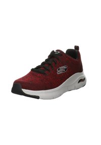 Scarpe sportive a maglia rosse e nere con lacci neri, suola ammortizzata, intersuola bianca e accento del logo di lato. Punta arrotondata con design testurizzato.
