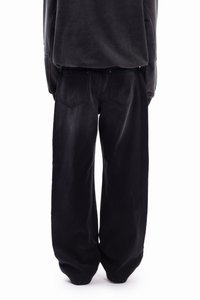 Svarte vide olabukser med høy midje, med to baklommer og en avslappet passform. Stoffet har en myk, litt slitt tekstur.