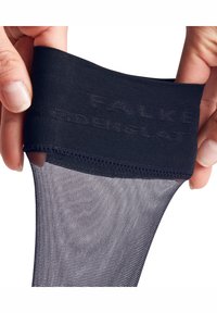 Collants pretos transparentes com uma cintura lisa, apresentando uma marcação subtil. A textura parece suave e leve, com um acabamento transparente.