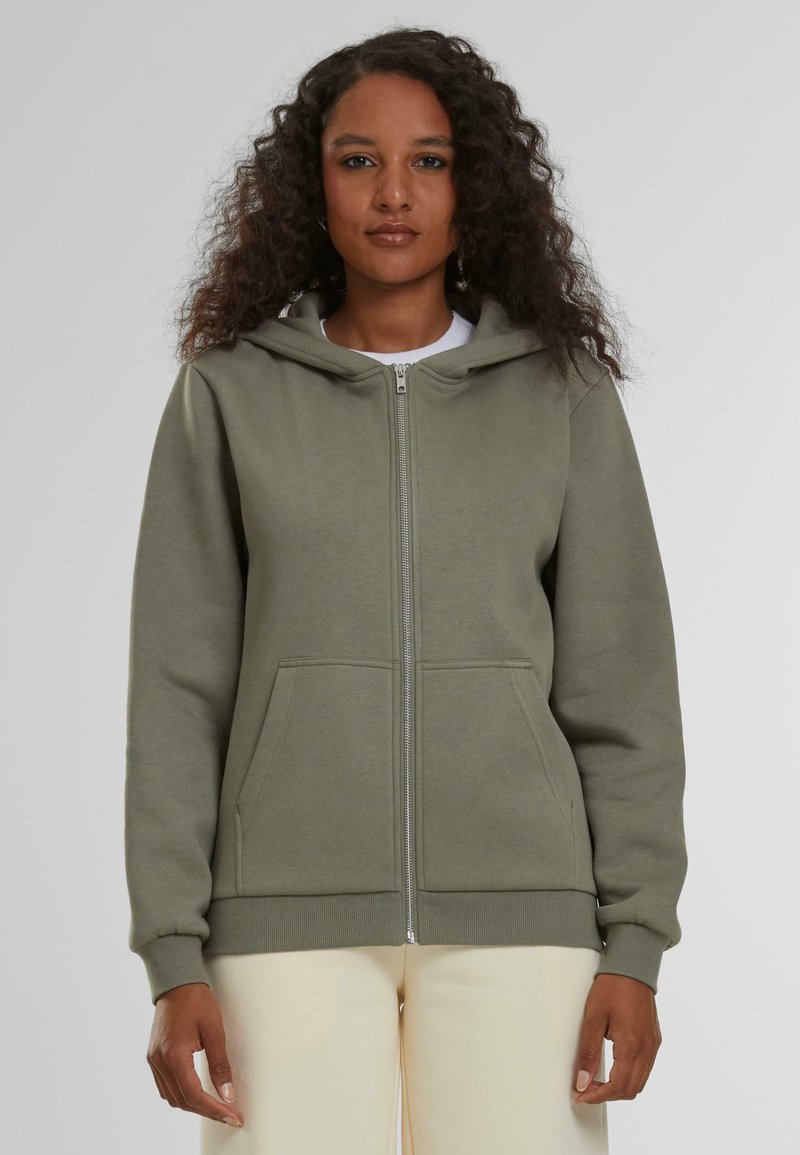 Sudadera verde con cremallera hecha de tela suave, con capucha ajustable, bolsillos frontales y puños y dobladillo acanalados.