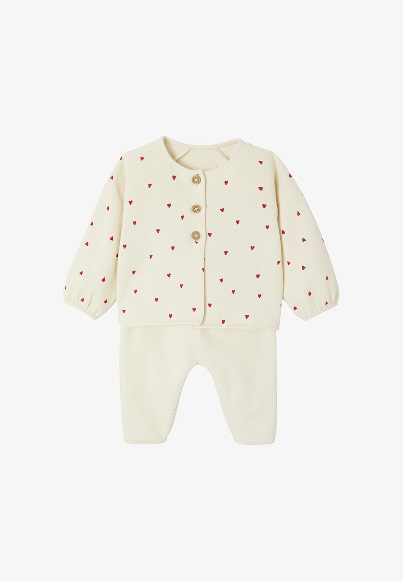 Cremfarbener Zweiteiler für Babys mit kleinem roten Herzmuster, bestehend aus einer langärmeligen Strickjacke und passenden Hosen, mit Holzknopfverschluss.