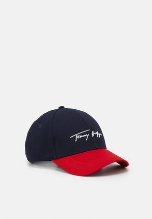 Marineblauwe honkbalpet met een rood gebogen klepje en een wit geborduurd "Tommy Hilfiger" logo op het voorpaneel.