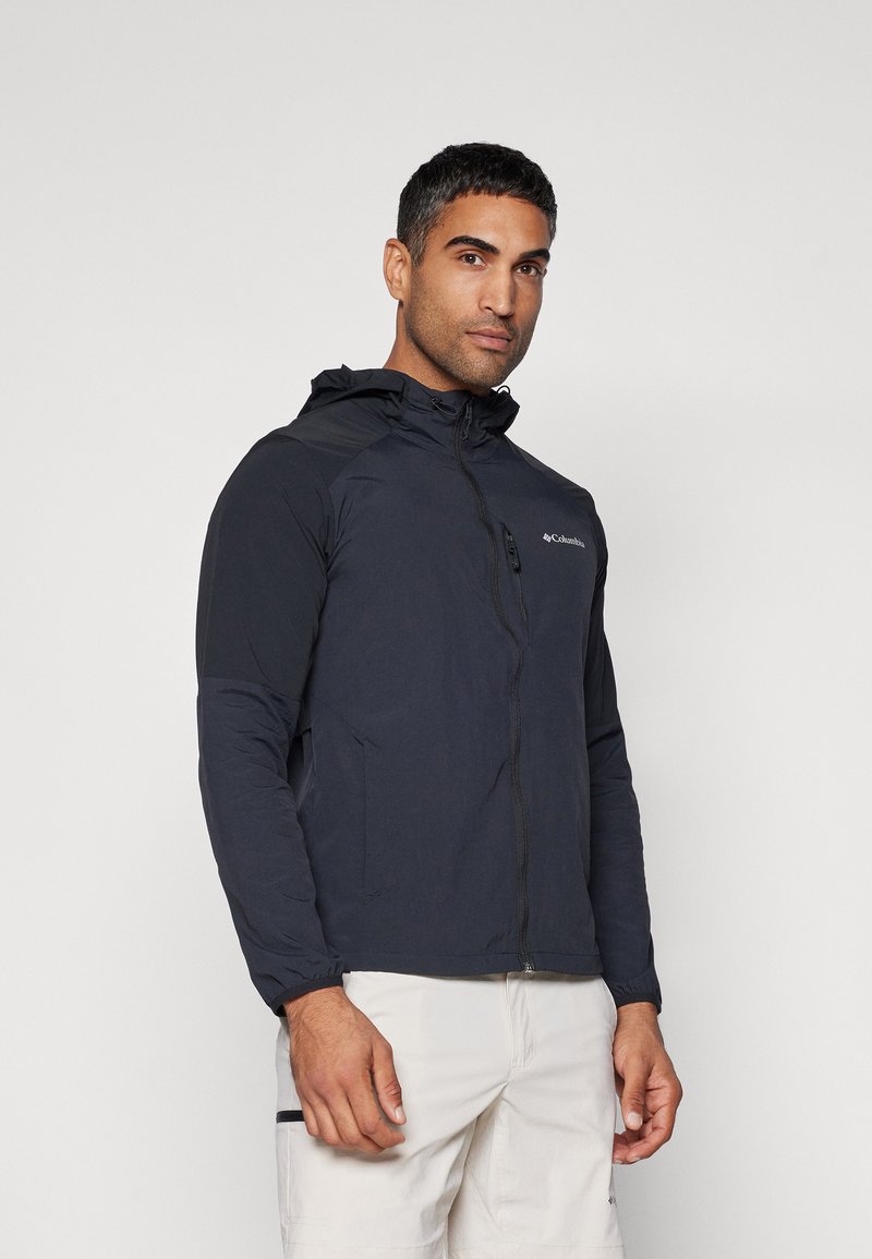 Men's dark gray Columbia jacket with a hood, full zip, and elastic cuffs, featuring a logo on the left chest and a lightweight design.