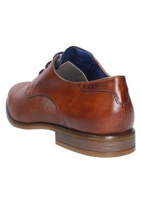 Braune Lederdressschuhe mit glatter Oberfläche und subtilen Rippendetails an der Seite. Mit einer abgerundeten Zehenpartie und einem niedrigen gestapelten Absatz.