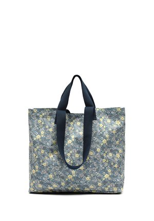 Grand sac fourre-tout avec des anses bleu marine et un tissu bleu recouvert de petits motifs floraux jaunes et blancs.