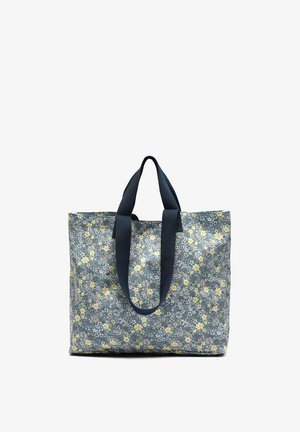 Large tote bag with navy blue handles and a blue fabric covered in small yellow and white flower patterns.
