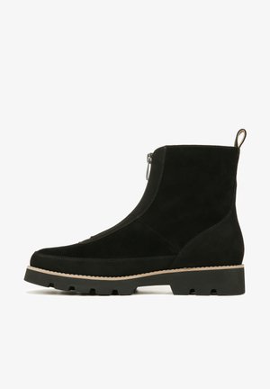 Zwarte suède enkellaars met een gestructureerd oppervlak, zijritssluiting en een contrasterende beige zool. Stevig ontwerp met minimale accenten.