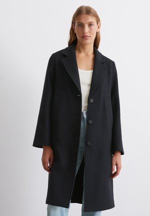 Marineblauer Wollmantel mit Reverskragen, drei Knöpfen und Seitentaschen; knielang mit gerader Silhouette und weicher Textur.