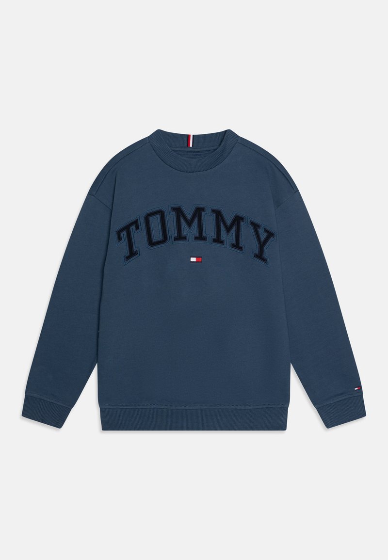 Tamno plavi dukserica od mješavine pamuka. Sadrži "TOMMY" u izbočenim slovima preko prednje strane, s malim logotipom uz rub.