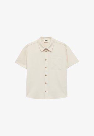 Lyhythihainen napillinen paita vaaleanbeigessä kankaassa. Siinä on terävä kaulus, viisi vastaavaa nappia ja rintatasku. Päällä sileä rakenne.