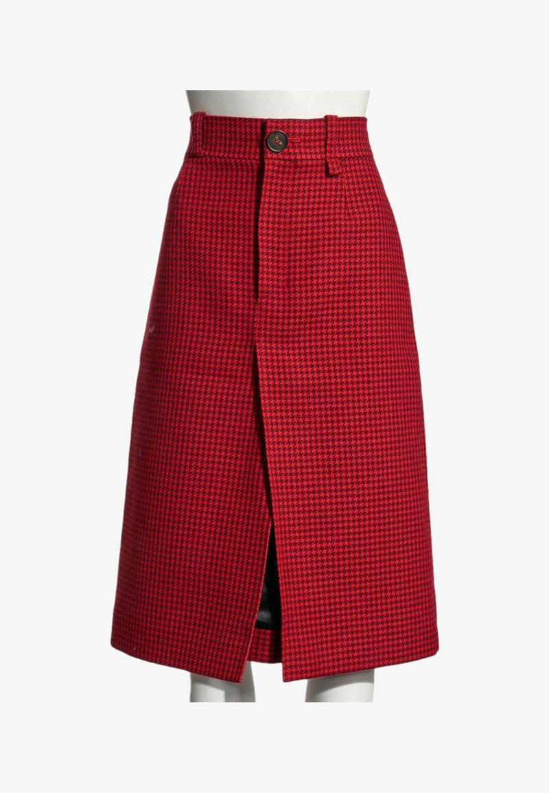 Jupe à carreaux pied-de-poule rouge et noire longueur genou avec une fente devant et un seul bouton visible à la taille sur un mannequin.