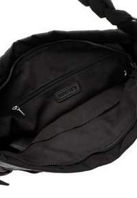 Zwarte stoffen handtas interieur met een gladde textuur, ritszak en een geperst "SURI FREY" logo. Kenmerkt zich door een zachte voering en geen zichtbare patronen.