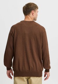 Brown knitted sweater featuring a textured fabric, round neck, and ribbed cuffs and hem. The design is casual with a relaxed fit.