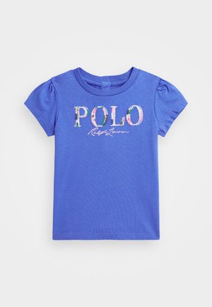 Kék pamut, rövid ujjú póló puffos ujjakkal, rajta színes virágmintával a "POLO" felirattal és alatta írott betűkkel a "Ralph Lauren" felirattal.