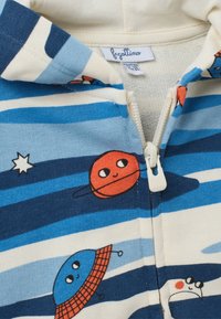 Felpa con zip in crema con righe blu, grafiche di pianeti giocosi in rosso e blu e una cerniera bianca.