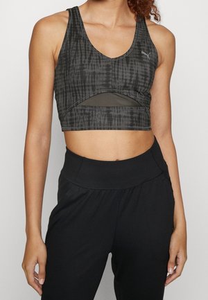 Black and gray cropped sports bra with a v-neck, textured pattern, and mesh cutout detail. Paired with high-waisted black pants.
