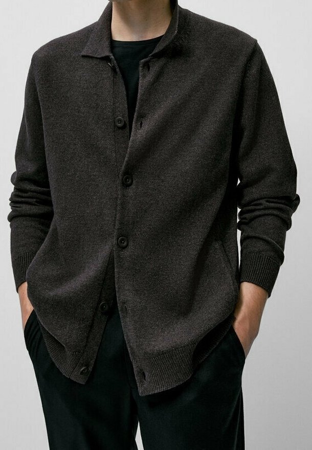 Cardigan marron foncé avec un col chemise, une fermeture à boutons sur le devant et des poignets côtelés. Confectionné en tissu tricoté doux, il présente une coupe décontractée.