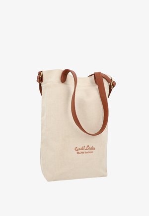 Beżowa torba typu tote z płótna z brązowymi skórzanymi paskami i nadrukiem "Gusti Leder SLOW fashion" na przodzie.