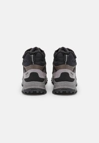 Chaussures de randonnée noires et grises avec des tiges texturées, des cols rembourrés, des semelles robustes et des accents réfléchissants. Logo visible sur le côté latéral.