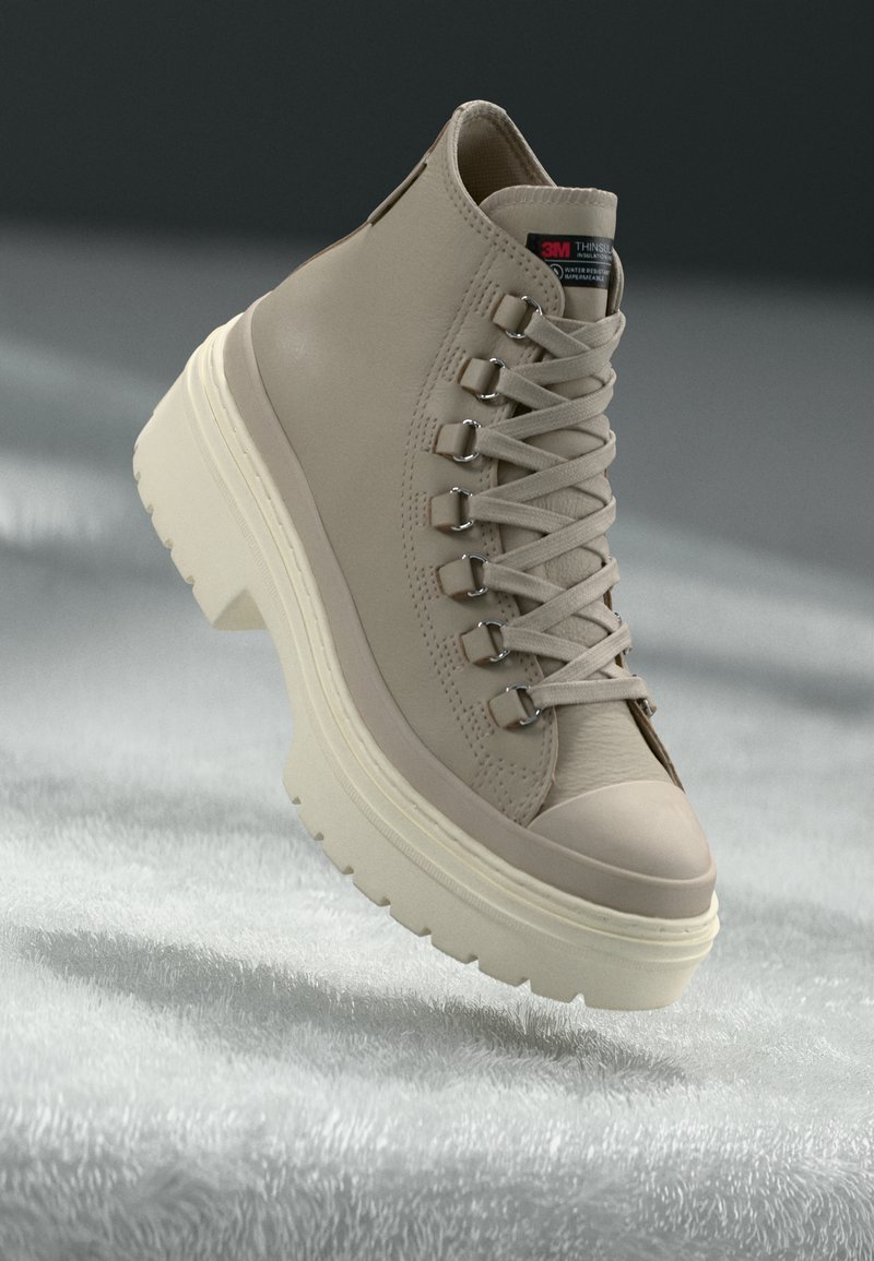 Beige Mid-Cut Sneaker mit Obermaterial aus glattem Leder, strukturiertem Gummisohle, hervorstehenden Metallösen und flachen Schnürsenkeln, mit leicht erhöhtem Absatz.