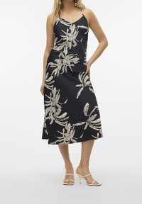 Robe midi fleurie noire avec imprimé botanique crème, dotée de fines bretelles et d'une silhouette décontractée, confectionnée en tissu lisse.