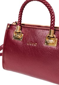 Borsa in pelle bordeaux con manico intrecciato, dettagli in hardware dorato e chiusura con zip. Presenta una placca con logo e una finitura testurizzata.