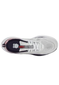 Weißer Sportschuh mit Obermaterial aus Mesh, strukturiertem Design, schwarzen und roten Akzenten sowie Schnürverschluss. Deutlich sichtbar ist ein Logo auf der Zunge.