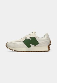 White sneaker with a green accent, featuring a textured suede material, round toe, and a beige rubber sole with a patterned grip.
