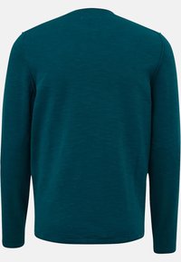 Maglietta a maniche lunghe con scollo tondo in un profondo teal. Realizzata in un tessuto morbido e testurizzato con una finitura liscia. Presenta cuciture minime e senza loghi visibili.