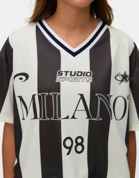 Melnā un baltā svītrainā īsām piedurknēm T-krekls ar uzdoto tekstu "MILANO" un "98" priekšā. Iespējojuma V-veida kakla izgriezums un logo detaļa uz krūtīm.