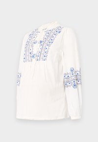 Blusa bianca a maniche lunghe con motivi floreali ricamati in blu sul busto e sulle maniche. Include un nastro al collo e polsini arricciati.