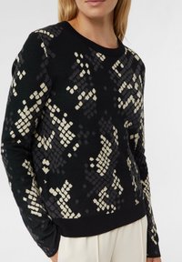 Schwarzer Pullover mit strukturiertem cremedeck und grauem Rautenmuster, Rundhalsausschnitt, langen Ärmeln und geripptem Saum. Aus weichem Strickmaterial.