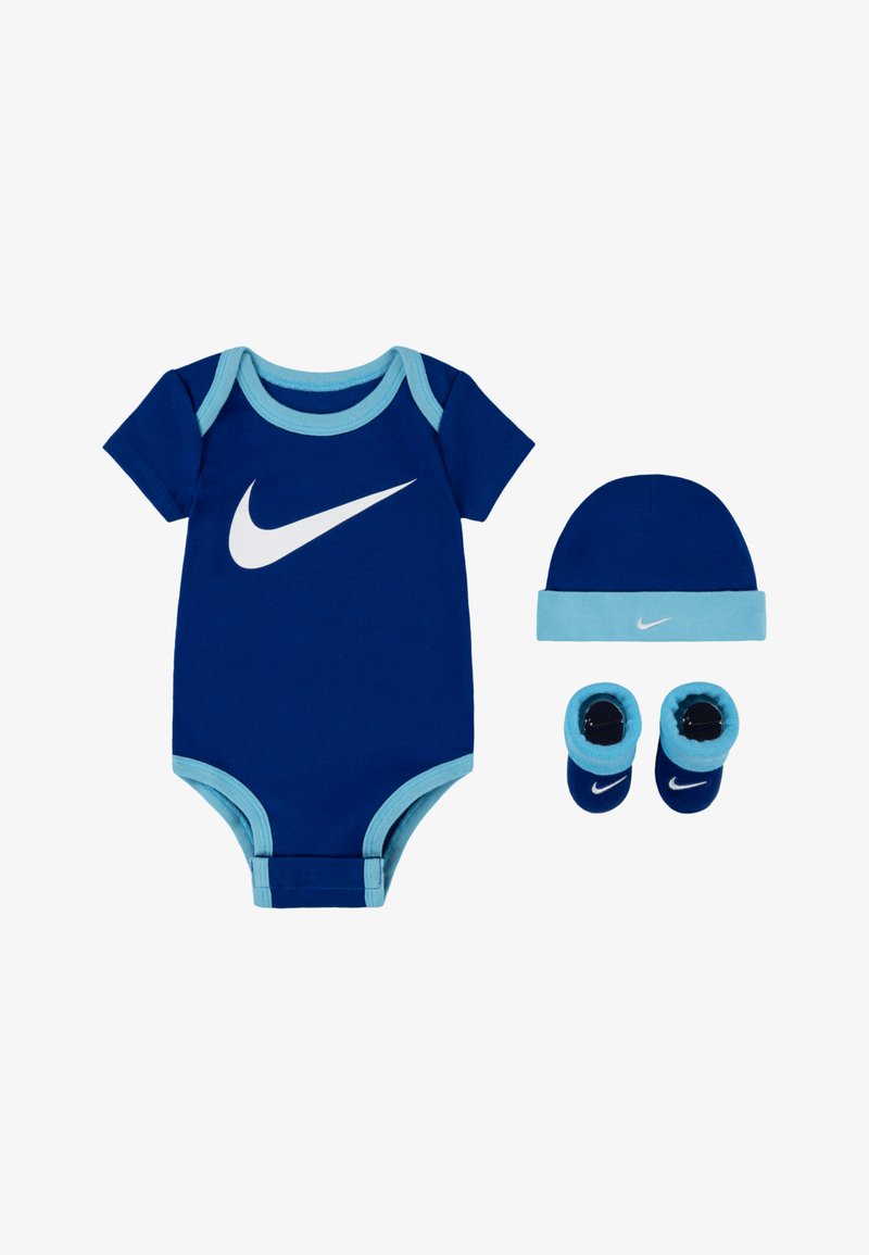 Kék pamut rugdalózó világoskék díszítéssel, nagy fehér Nike logóval. Tartalmaz egy hozzá illő sapkát és cipőt, szintén kék színben.