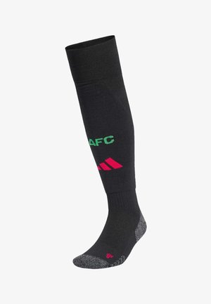 Black knee-high sock featuring green "AFC" lettering and pink Adidas logo, with a textured grey and pink footbed. Smooth knit material.