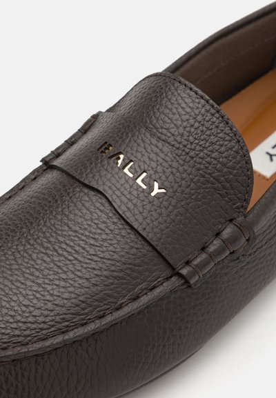 Tmavohnedé kožené mokasíny s textúrovaným povrchom, s pozláteným logom "BALLY" na hladkom páse a precízne prešitou ozdobou.