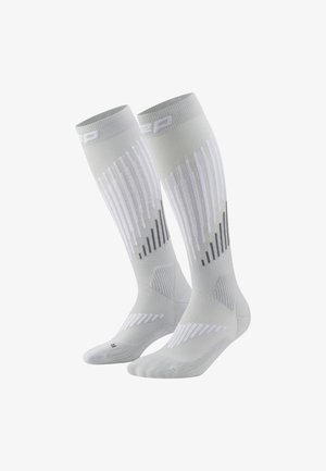 Kompressionssocken in Hellgrau, mit weißen und schwarzen diagonalen Streifen, gerippter Textur und gepolsterten Bereichen für zusätzlichen Halt.