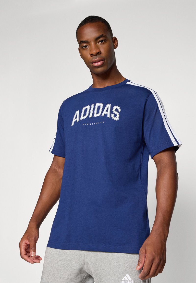 Granatowa bawełniana koszulka z krótkim rękawem z białym logo "ADIDAS", z kontrastowymi białymi paskami wzdłuż ramion.