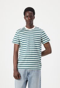 Striped t-shirt in blue, teal, and white. Short sleeves, crew neckline, made of soft cotton fabric. Light and breathable texture.