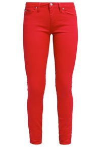 Czerwone wąskie dżinsy wykonane z mieszanki bawełny, o gładkiej fakturze, z kieszeniami z przodu oraz z zapięciem na zamek błyskawiczny i guzik.