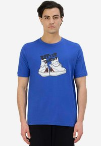 T-shirt in cotone blu con una stampa grafica di sneakers e la scritta "UNITE È MEGLIO" in nero, con maniche corte e scollo rotondo.
