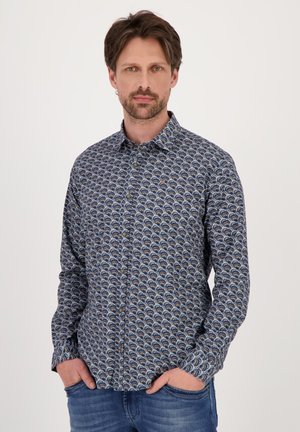 Een button-up blouse in navyblauwe stof met een golvenpatroon in crème en lichtblauw. Kenmerkt zich door een klassieke kraag en lange mouwen.