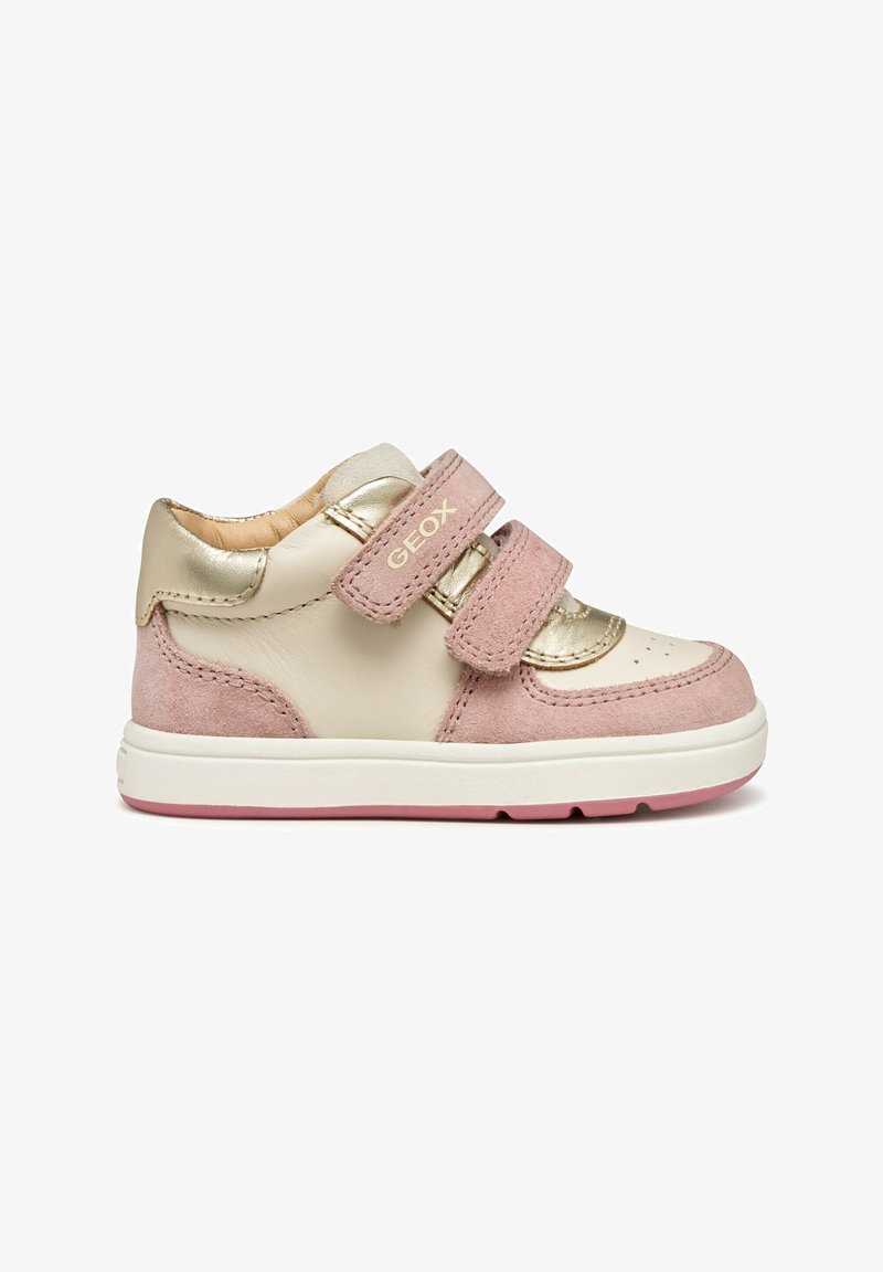 Sneaker rosa e beige con un accento metallico dorato, texture in camoscio, due fibbie in Velcro e una suola bianca con dettagli rosa.